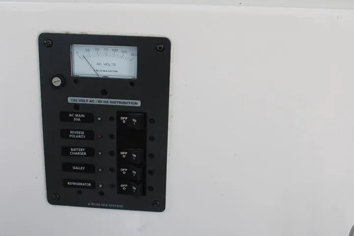 Slide: The Image of Electrical panel of a 2006 Trophy 2359 Pro boat with AC voltage meter and switches. - 28