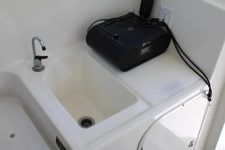 Slide: The Image of 2006 Trophy 2359 Pro boat sink area with electronic device on counter. - 36