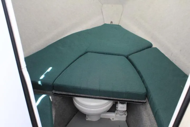 Slide: The Image of 2006 Trophy 2359 Pro cabin interior with green cushions and compact toilet. - 39