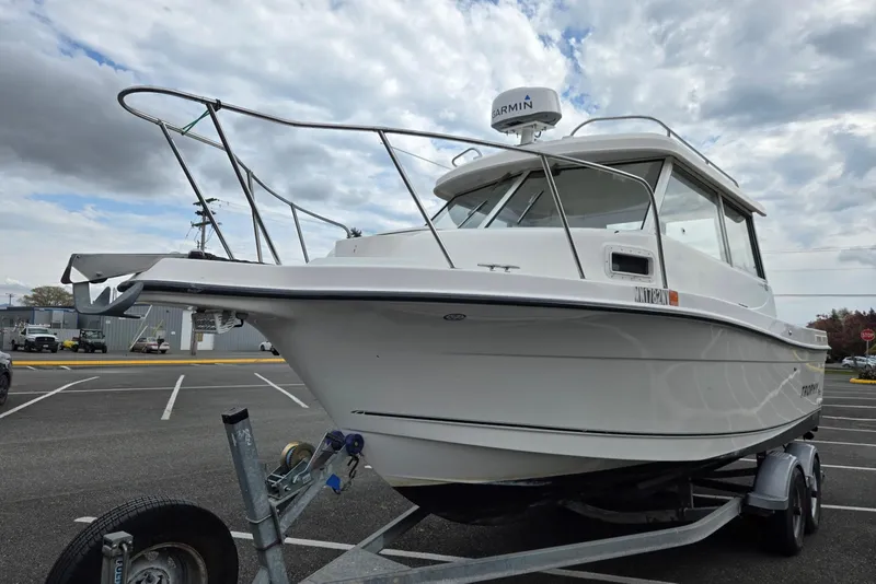 Slide: The Image of 2006 Trophy 2359 Pro boat on trailer in parking lot under cloudy sky. - 4