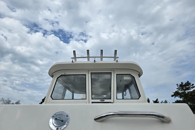 Slide: The Image of 2006 Trophy 2359 Pro boat against a cloudy sky, showcasing cabin and railing. - 8