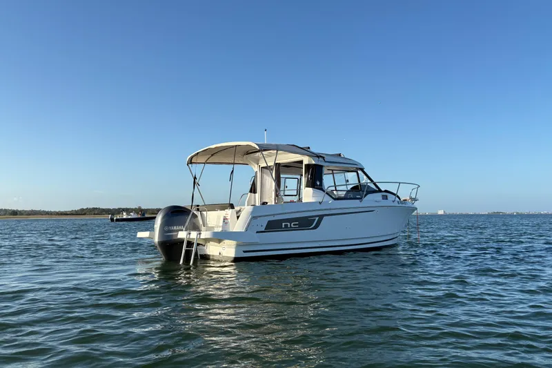 Slide: The Image of 2022 Jeanneau NC 795 boat on calm water under clear blue sky. - 1