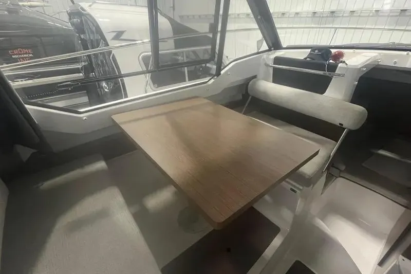 Slide: The Image of Interior of 2022 Jeanneau NC 795 boat with wooden table and seating area. - 7