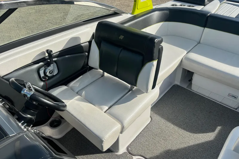 Slide: The Image of 2016 Four Winns TS222 boat interior with black and white seating and steering wheel. - 14