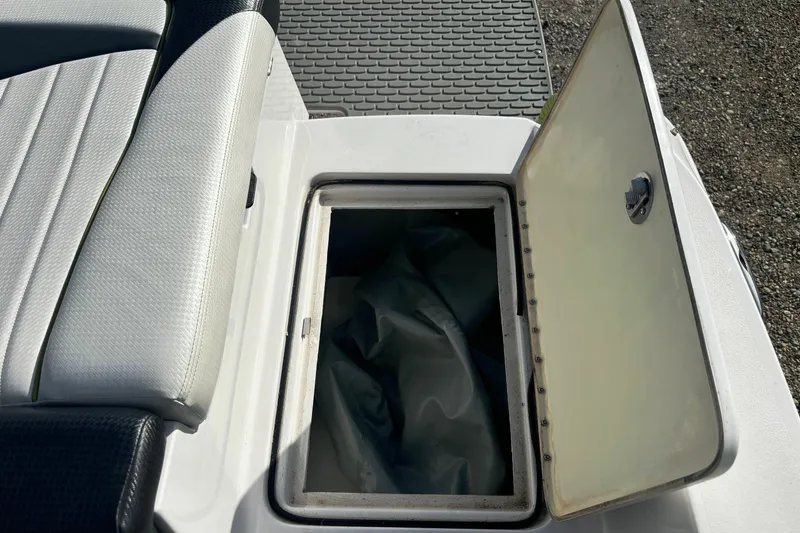 Slide: The Image of Open storage compartment on 2016 Four Winns TS222 boat, featuring cushioned seating. - 20
