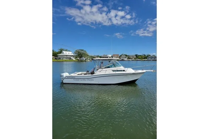 The Image of 1989 Grady-White Marlin 280 boat on calm water under a clear blue sky. - 1