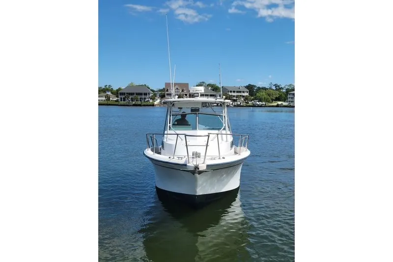 Slide: The Image of 1989 Grady-White Marlin 280 boat on calm water, clear sky background. - 2