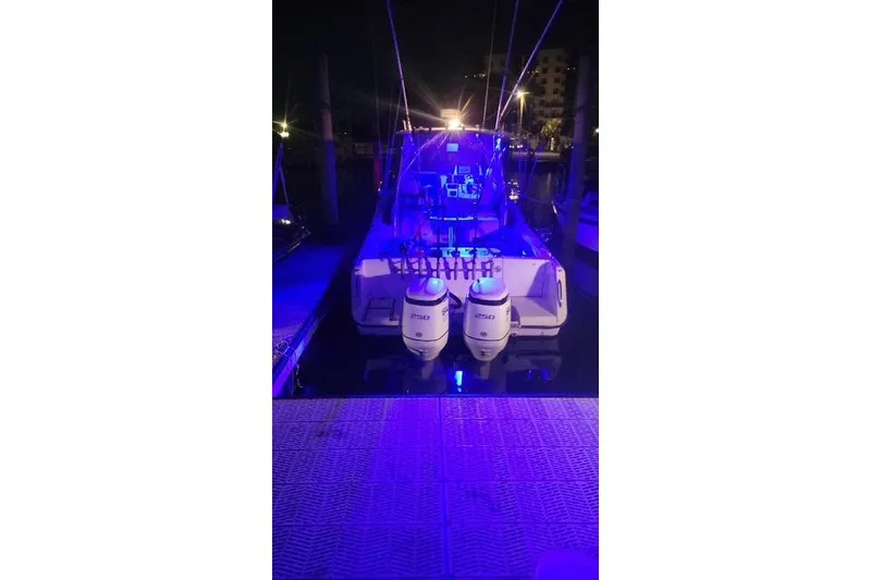 Slide: The Image of 1989 Grady-White Marlin 280 boat docked at night with blue lighting. - 4
