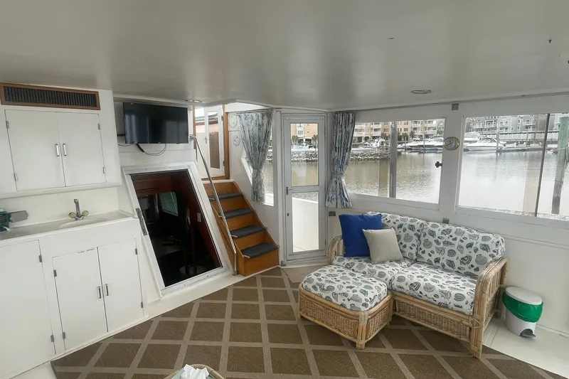 Slide: The Image of Interior of 2001 Novatec Islander boat with cozy seating and marina view. - 16