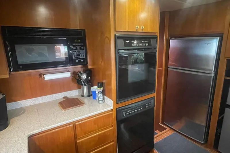 Slide: The Image of 2001 Novatec Islander kitchen with microwave, oven, and stainless steel refrigerator. - 27