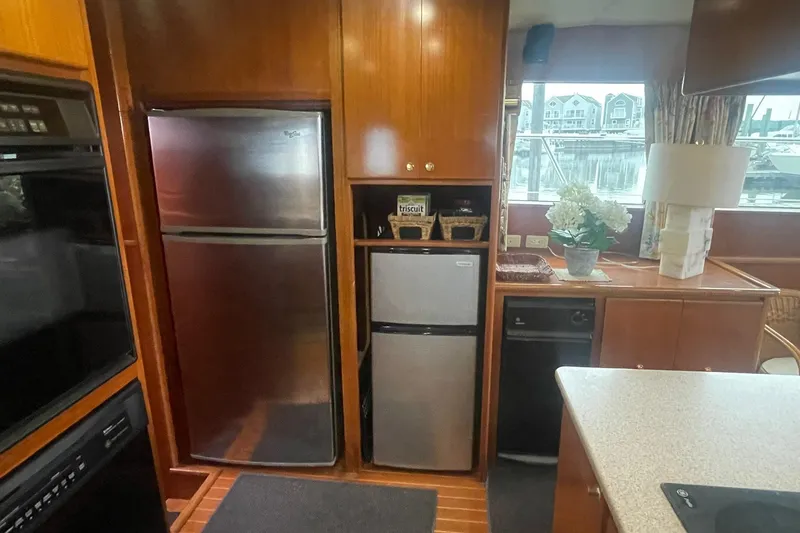 Slide: The Image of 2001 Novatec Islander yacht kitchen with stainless steel appliances and wooden cabinetry. - 28