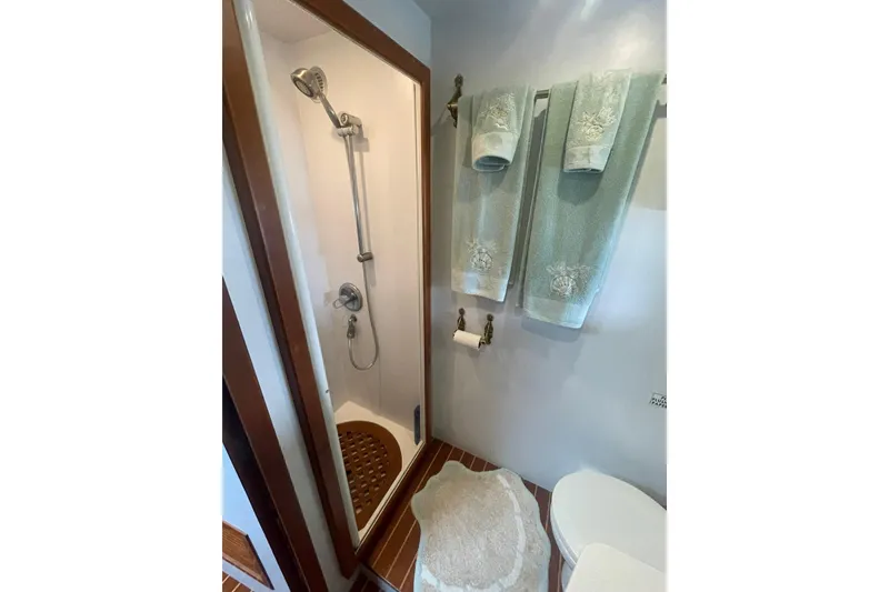 Slide: The Image of Compact bathroom with shower, towels, and toilet on a 2001 Novatec Islander yacht. - 35