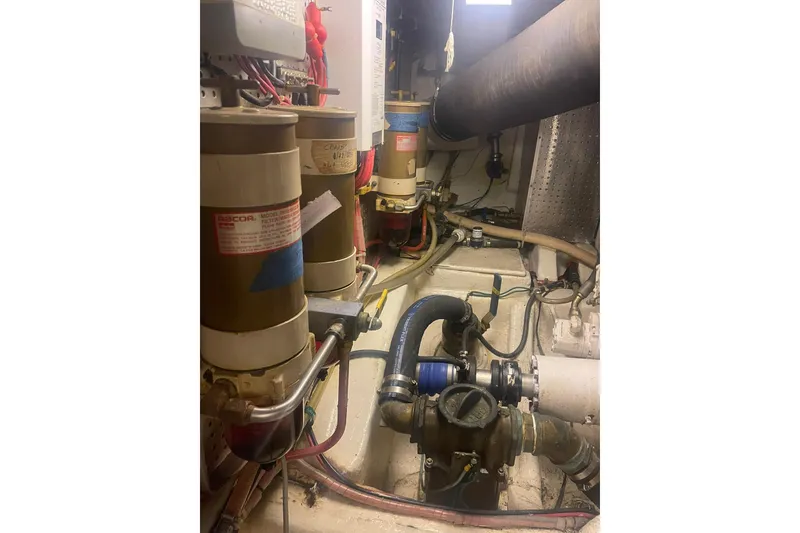Slide: The Image of Engine room of a 2001 Novatec Islander boat, featuring fuel filters and piping. - 46