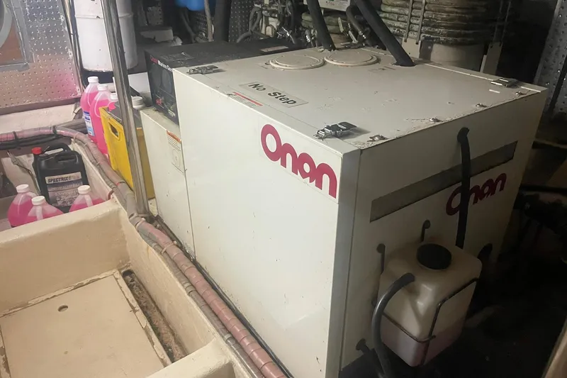 Slide: The Image of Onan generator in a 2001 Novatec Islander engine room with various maintenance supplies. - 47