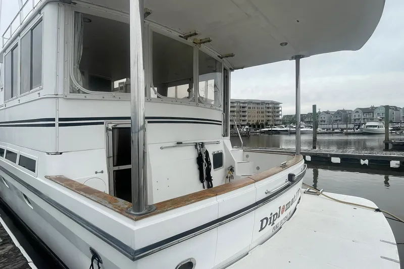 Slide: The Image of 2001 Novatec Islander yacht docked at marina, showcasing spacious deck and sleek design. - 7