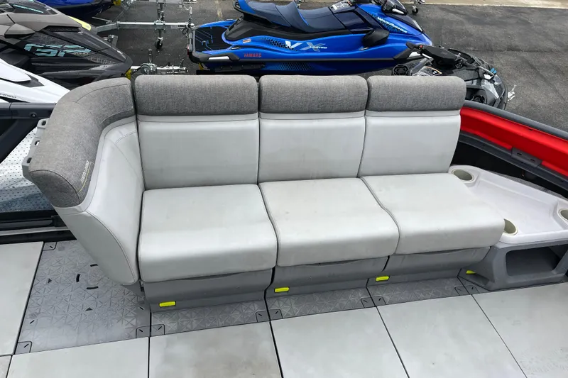 Slide: The Image of 2022 Sea-Doo Switch Cruise 21 interior seating with gray upholstery and cup holders. - 2