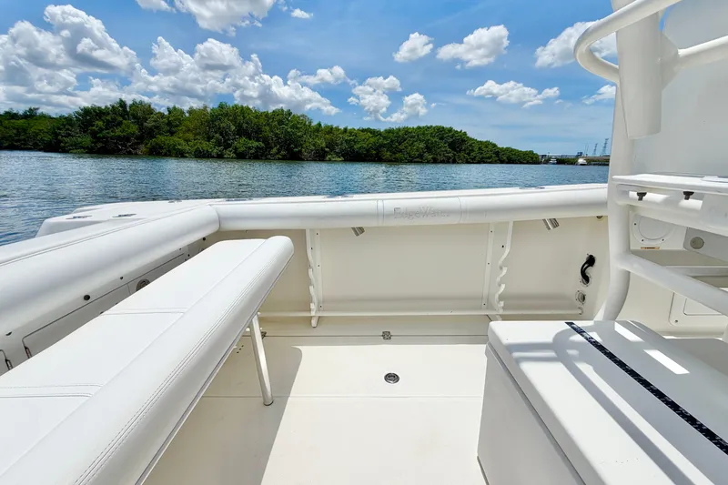 Slide: The Image of 2007 Edgewater 268CC boat interior with seating, overlooking calm water and lush greenery. - 12