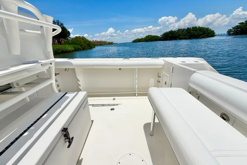 Slide: The Image of 2007 Edgewater 268CC boat interior with seating, overlooking serene water and lush greenery. - 14