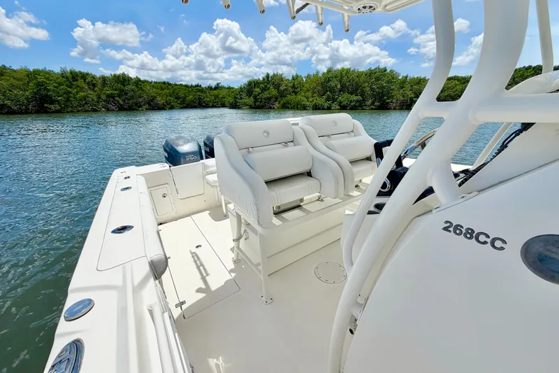 Slide: The Image of 2007 Edgewater 268CC boat on calm water, featuring spacious seating and lush greenery backdrop. - 15