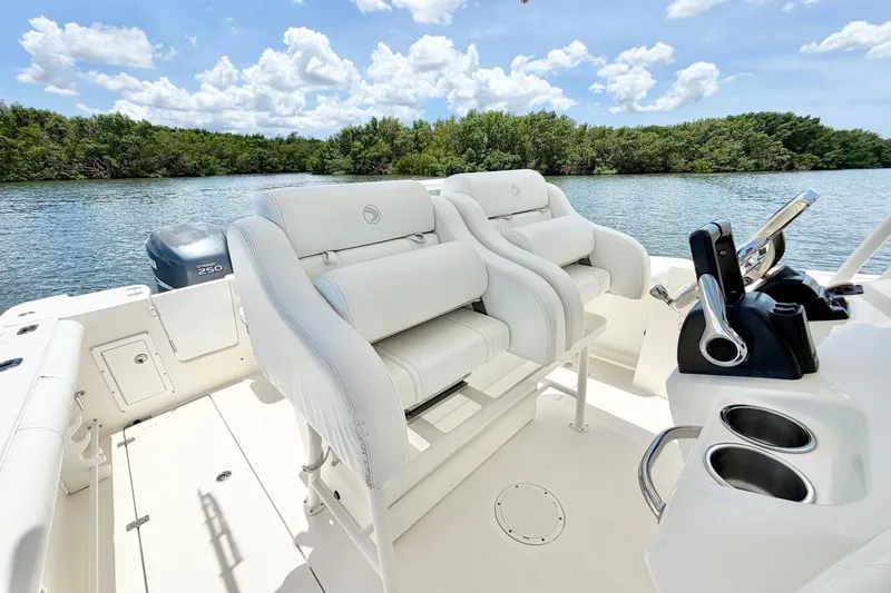Slide: The Image of 2007 Edgewater 268CC boat interior with white seating, steering console, and scenic water view. - 16