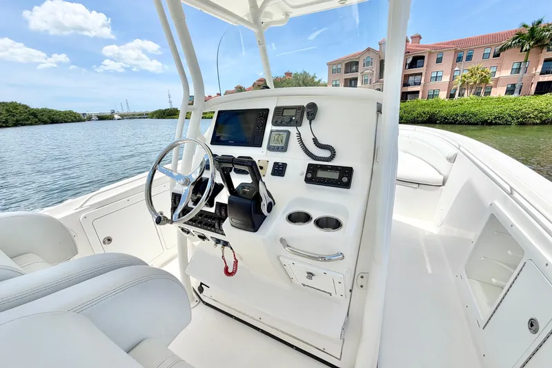 Slide: The Image of 2007 Edgewater 268CC boat cockpit with steering wheel, navigation controls, and waterfront view. - 17