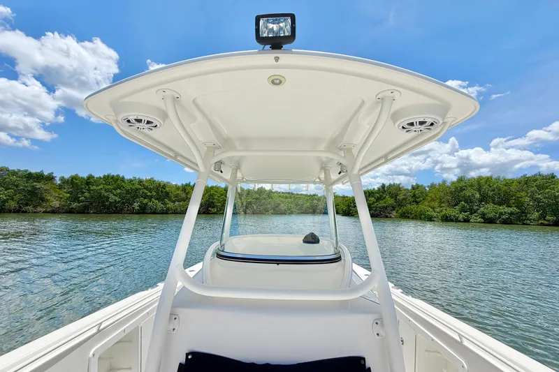 Slide: The Image of 2007 Edgewater 268CC boat on serene water with lush greenery and blue sky. - 18