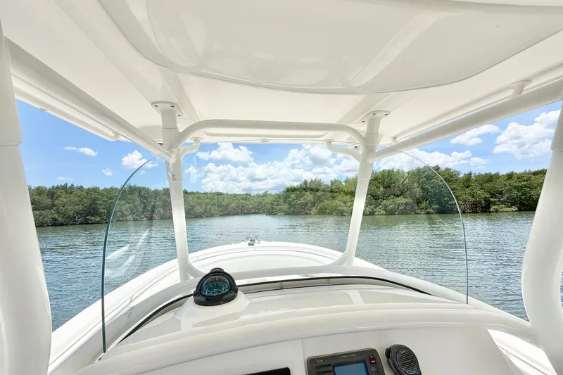 Slide: The Image of 2007 Edgewater 268CC boat navigating a serene river under a clear blue sky. - 19