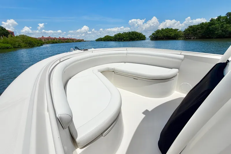 Slide: The Image of 2007 Edgewater 268CC boat with white seating, cruising on a scenic river. - 2