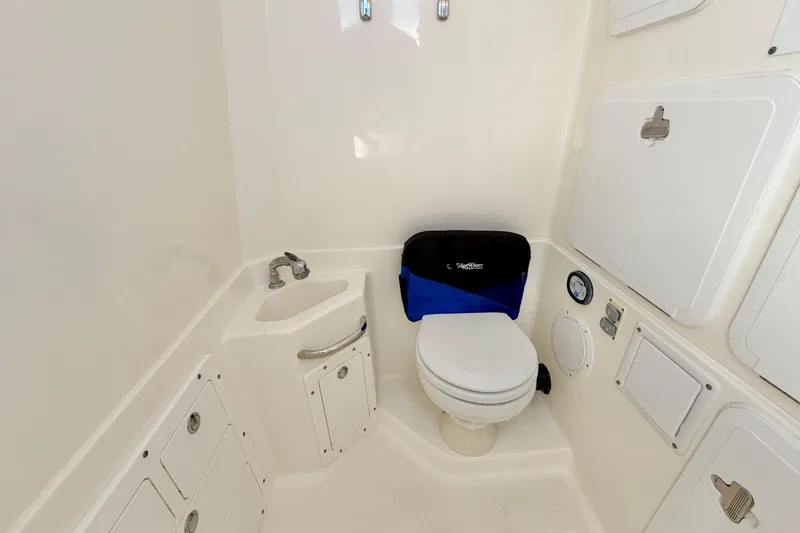 Slide: The Image of 2007 Edgewater 268CC boat bathroom with toilet, sink, and storage compartments. - 20