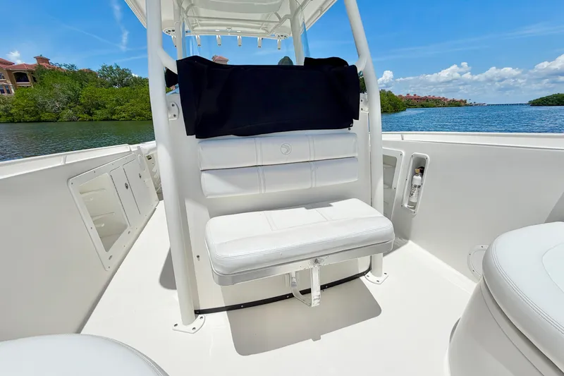 Slide: The Image of 2007 Edgewater 268CC boat interior with white seating, on a sunny day by the water. - 22