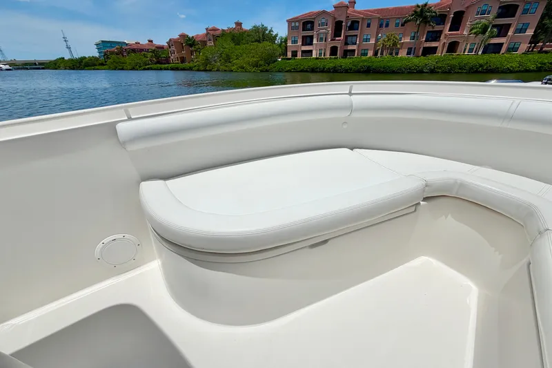 Slide: The Image of 2007 Edgewater 268CC boat interior with white seating, near waterfront buildings. - 23