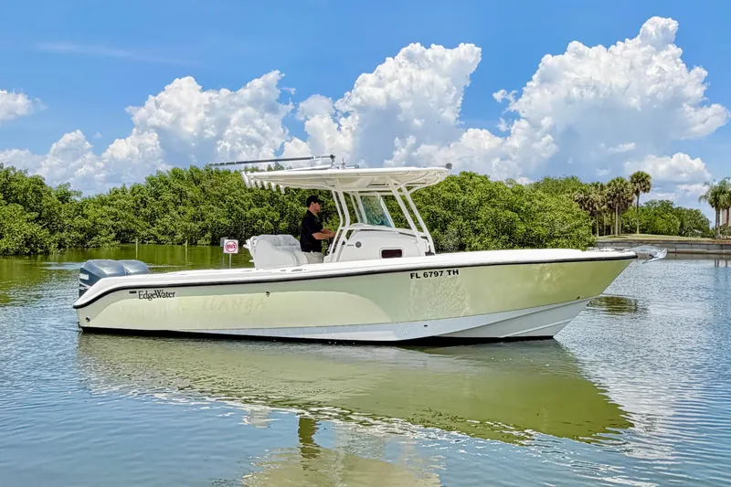 Slide: The Image of 2007 Edgewater 268CC boat on calm water, clear sky, lush greenery background. - 5