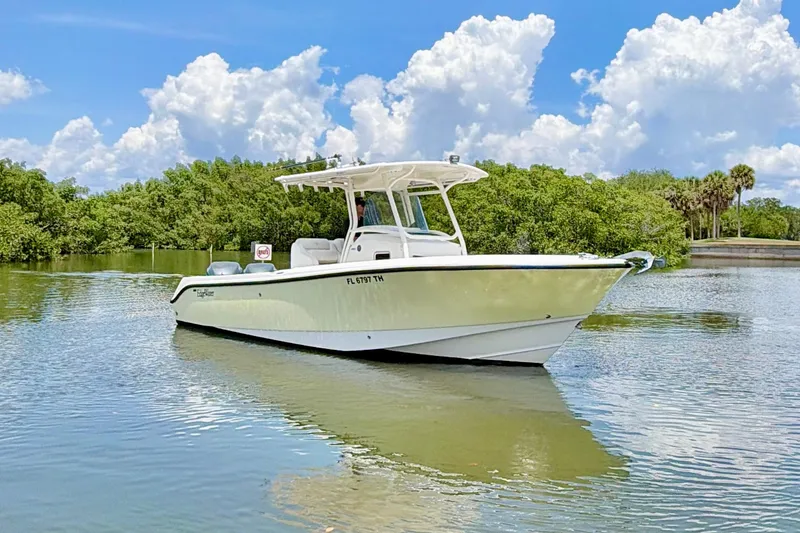 Slide: The Image of 2007 Edgewater 268CC boat on calm water, surrounded by lush greenery and blue sky. - 6