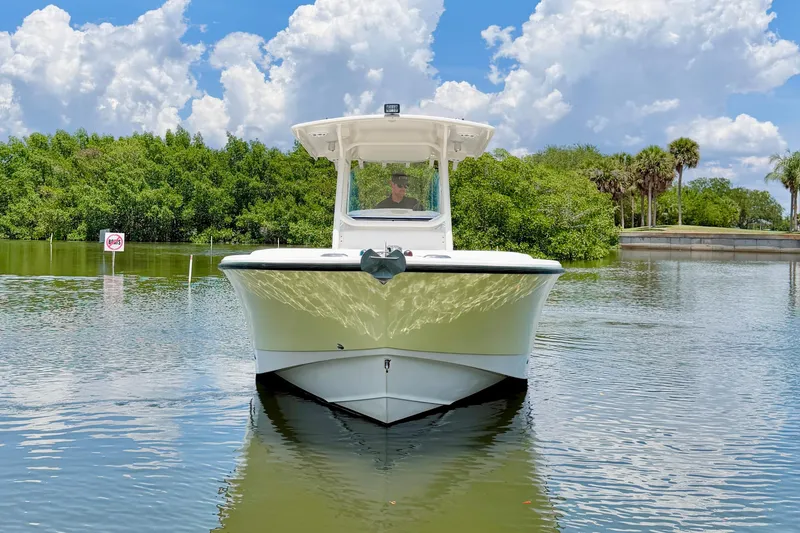 Slide: The Image of 2007 Edgewater 268CC boat on calm water with lush greenery and cloudy sky. - 7
