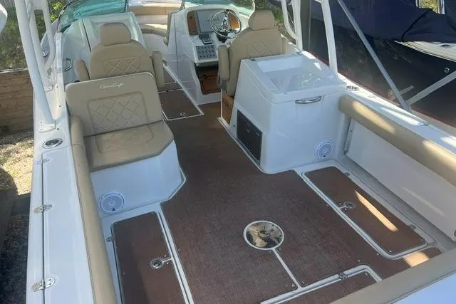 Slide: The Image of 2017 Chris-Craft Calypso 26 boat interior with beige seating and wood accents. - 11