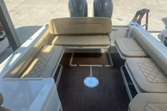 Slide: The Image of 2017 Chris-Craft Calypso 26 boat interior with beige seating and twin engines. - 12