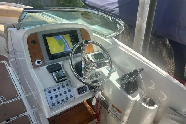 Slide: The Image of 2017 Chris-Craft Calypso 26 boat dashboard with steering wheel and navigation display. - 13