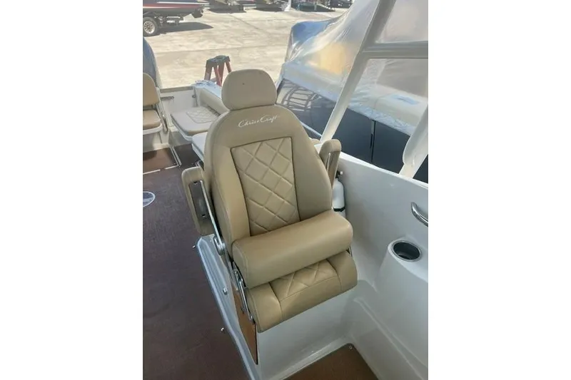 Slide: The Image of Luxurious seating on 2017 Chris-Craft Calypso 26 boat, featuring beige upholstery and diamond stitching. - 16