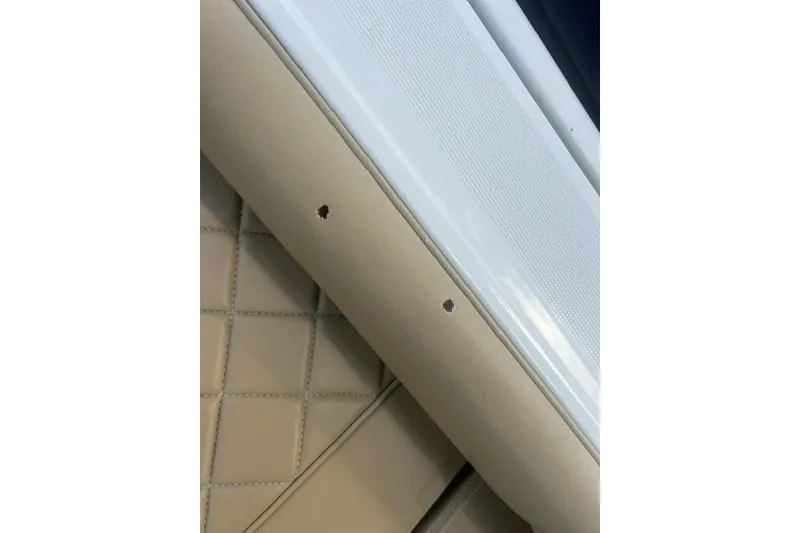 Slide: The Image of Close-up of 2017 Chris-Craft Calypso 26 interior, featuring beige upholstery and white trim. - 18