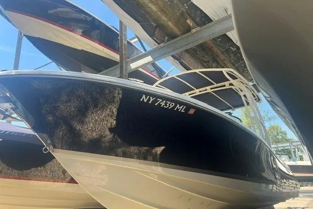 Slide: The Image of 2017 Chris-Craft Calypso 26 boat in storage, showcasing sleek design and registration number NY 7439 ML. - 4