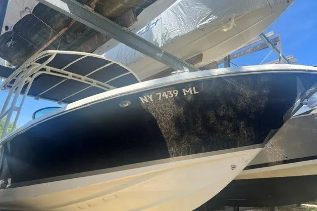 Slide: The Image of 2017 Chris-Craft Calypso 26 boat with registration NY 7439 ML, docked under a canopy. - 5