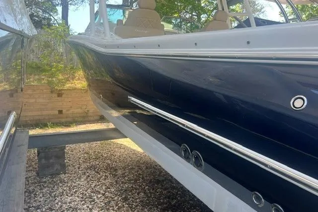 Slide: The Image of 2017 Chris-Craft Calypso 26 boat with sleek blue hull on a trailer. - 6