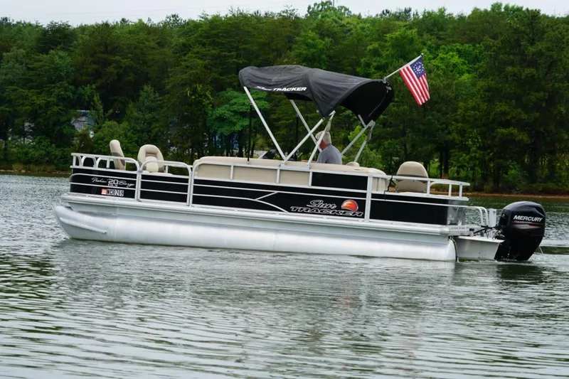 The Image of 2016 Sun Tracker Fishin' Barge 20 DLX pontoon boat on a serene lake. - 0