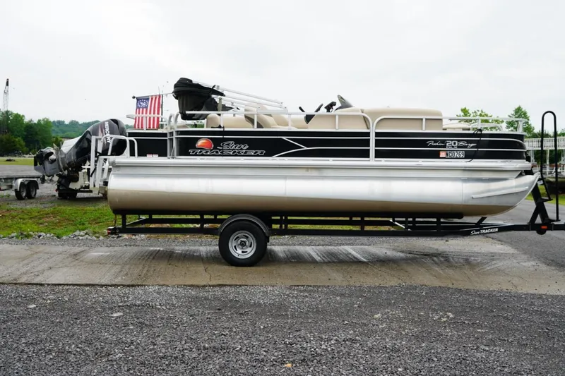 Slide: The Image of 2016 Sun Tracker Fishin' Barge 20 DLX pontoon boat on trailer, parked outdoors. - 11