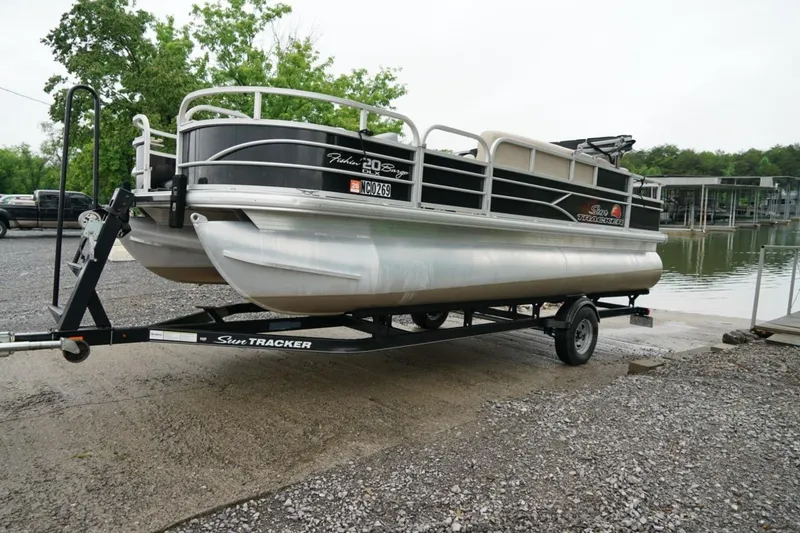 Slide: The Image of 2016 Sun Tracker Fishin' Barge 20 DLX pontoon boat on trailer by a lake. - 12