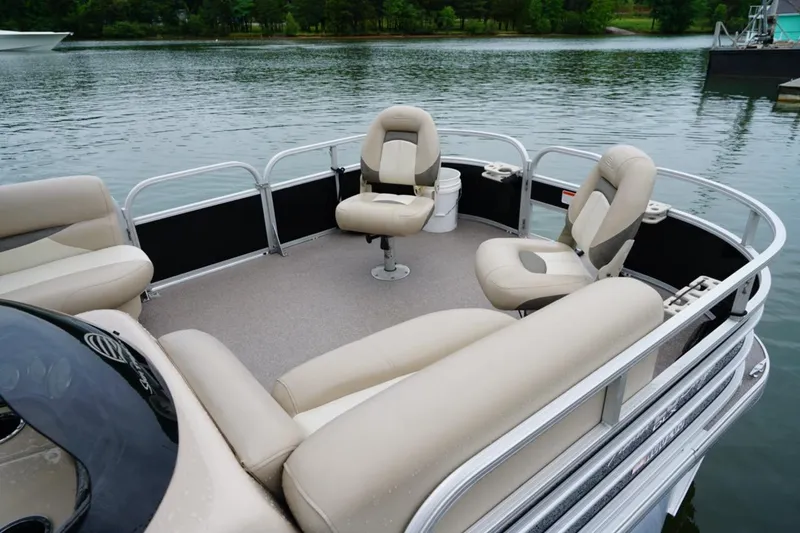Slide: The Image of 2016 Sun Tracker Fishin' Barge 20 DLX pontoon boat with beige seating on a calm lake. - 6