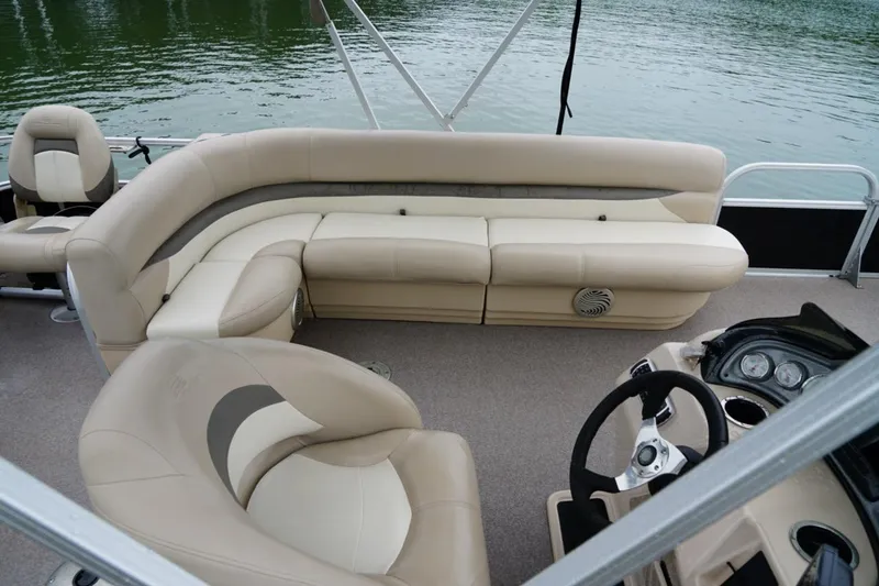 Slide: The Image of 2016 Sun Tracker Fishin' Barge 20 DLX interior with beige seating and steering console. - 7
