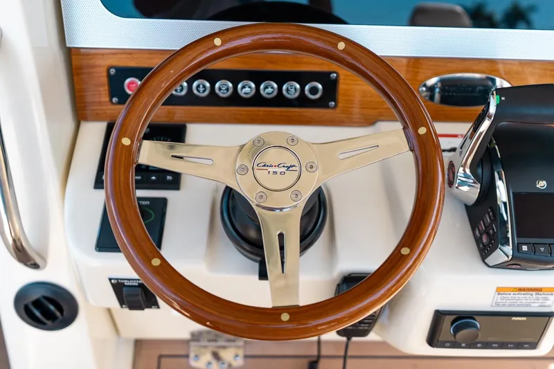 Slide: The Image of 2024 Chris-Craft Catalina 30 helm with wooden steering wheel and modern controls. - 19