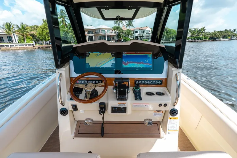 Slide: The Image of 2024 Chris-Craft Catalina 30 helm with advanced navigation system on a serene waterway. - 21
