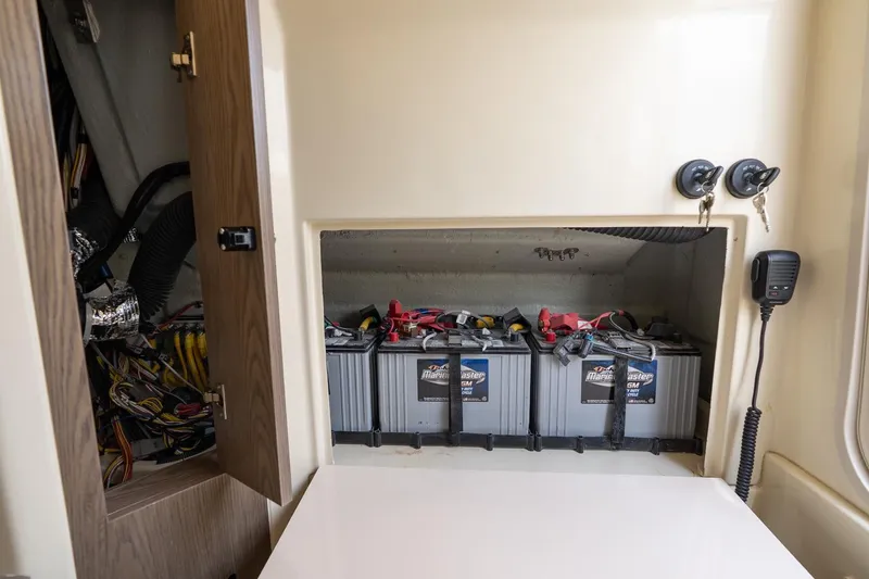 Slide: The Image of Battery compartment of 2024 Chris-Craft Catalina 30, showcasing marine batteries and wiring. - 28